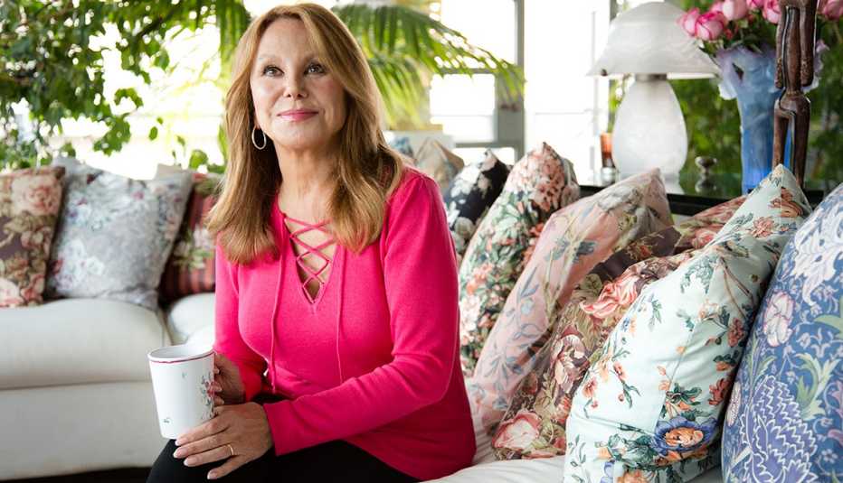 Marlo Thomas sitting on a couch.