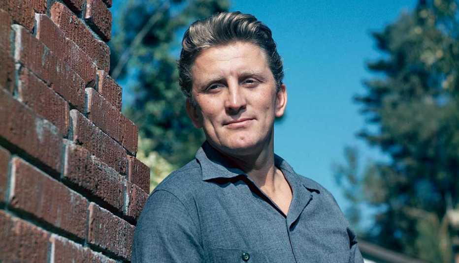 kirk douglas standing by brick wall circa 1955