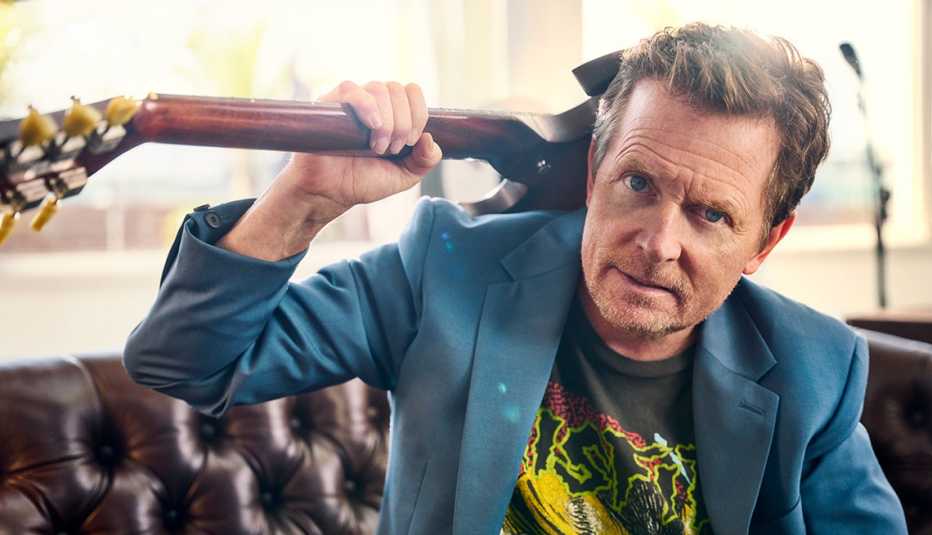 closeup of Michael J Fox with a guitar slung over his shoulder
