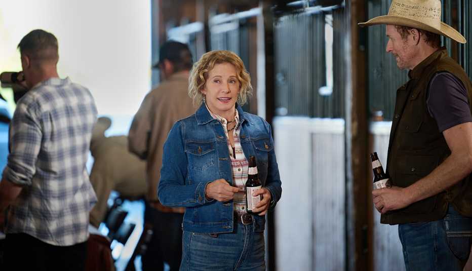 nancy travis as isabel mcmurray and beau mirchoff as cash mcmurray in a stable both holding bottles 