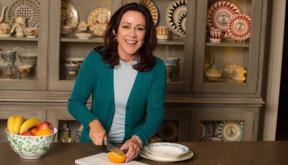 patricia heaton in a kitchen slicing an orange