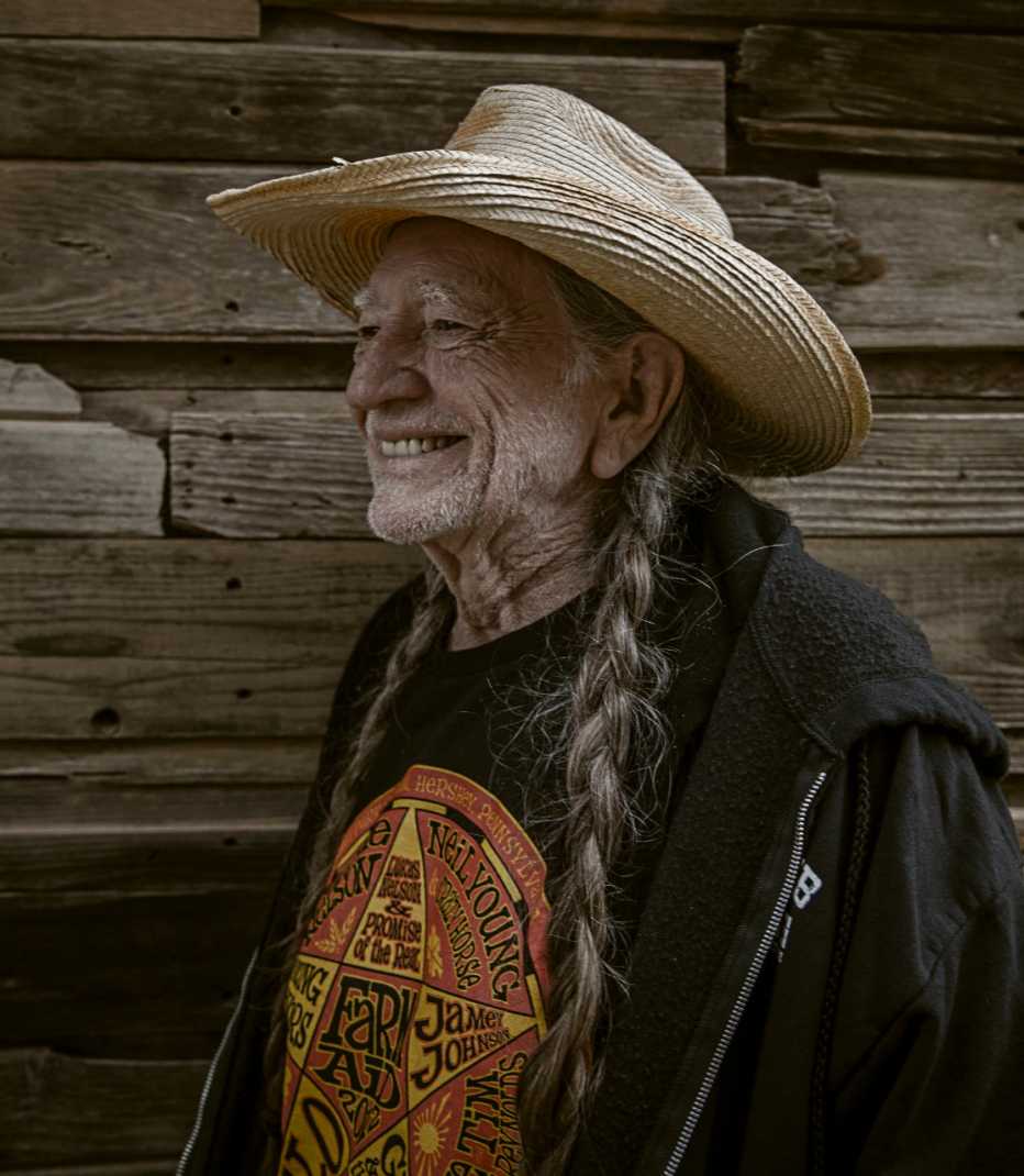 Wille Nelson with a hat on and smiling 