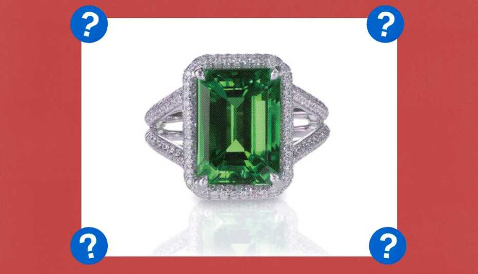 Green emerald diamond ring; surrounded by blue circles with question marks in them