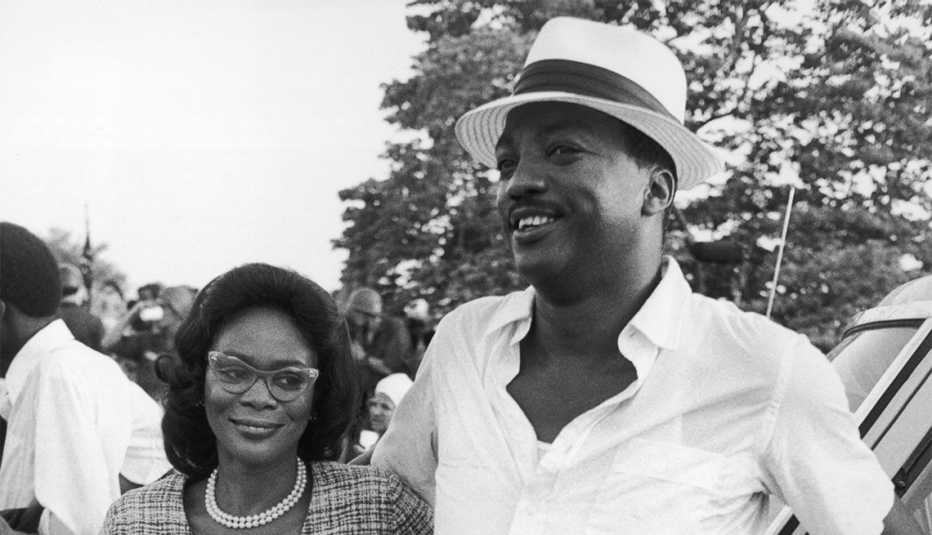 Actors Cicely Tyson and Paul Winfield, wearing period costumes, smile while leaning against a car in a promotional portrait for the TV miniseries 'King'. 