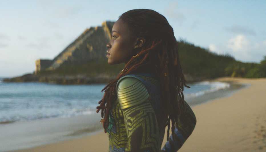 Lupita Nyong'o standing on a beach looking out at the water in the film Black Panther: Wakanda Forever