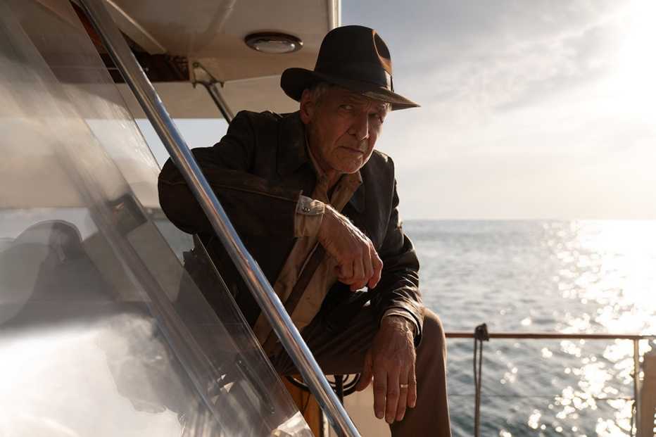 Harrison Ford reprises his role as Indiana Jones in the film, "Indiana Jones and the Dial of Destiny." harrison ford kneeling on a boat in the film indiana jones and the dial of destiny