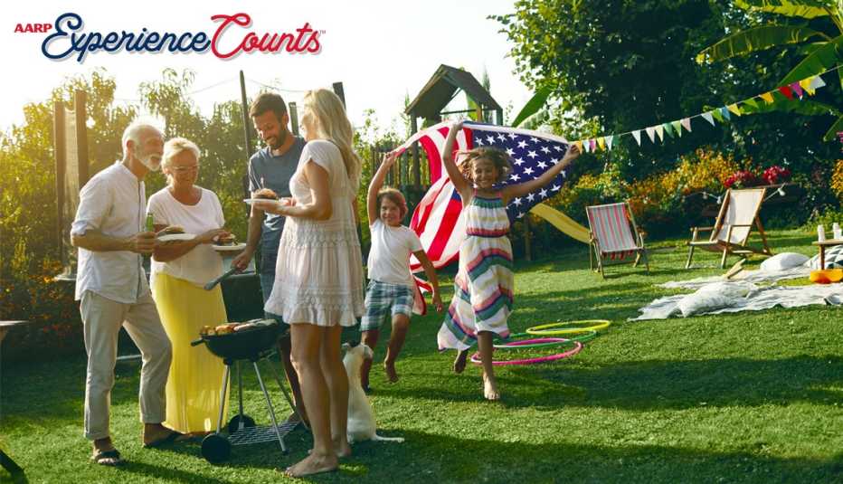 several people representing multiple generations smile while talking to each other at a barbecue