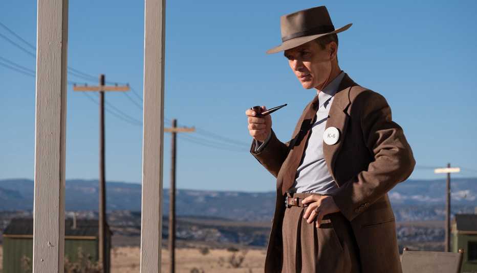 Cillian Murphy in the film, "Oppenheimer." cillian murphy holding a pipe in his hand in a scene from the film oppenheimer
