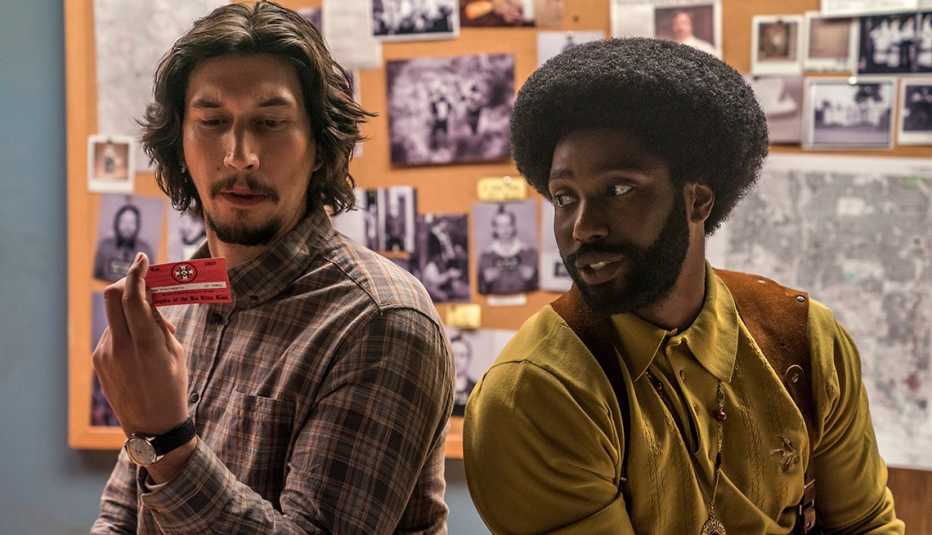Adam Driver and John David Washington sitting next to each other.