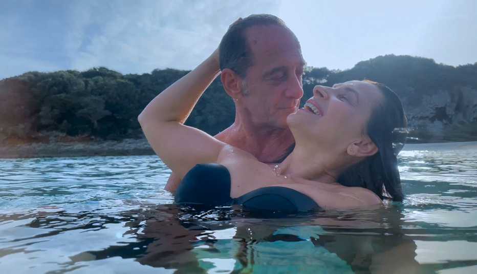 Vincent Lindon and Juliette Binoche embrace in a body of water in the film Both Sides of the Blade