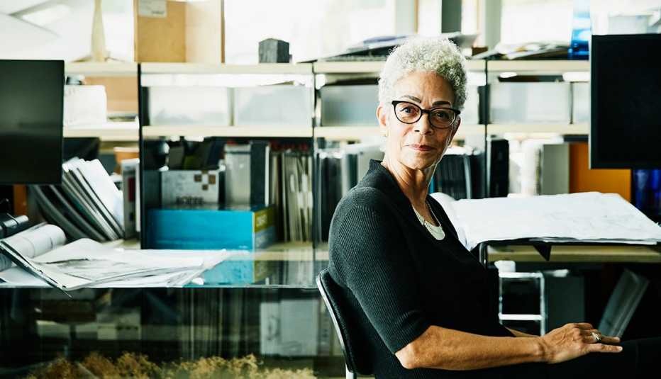 Woman sitting in her office, looking thoughtful.