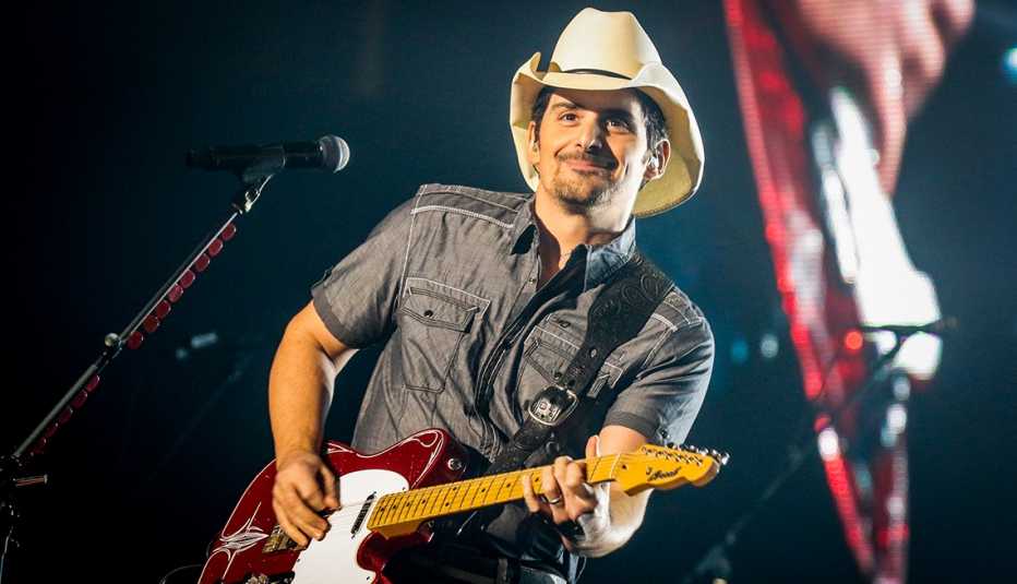 brad paisley in a cowboy hat playing guitar during a performance