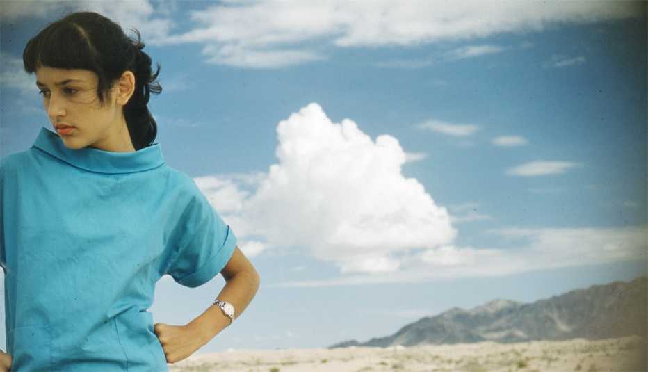 joan baez standing outside with clouds in the background