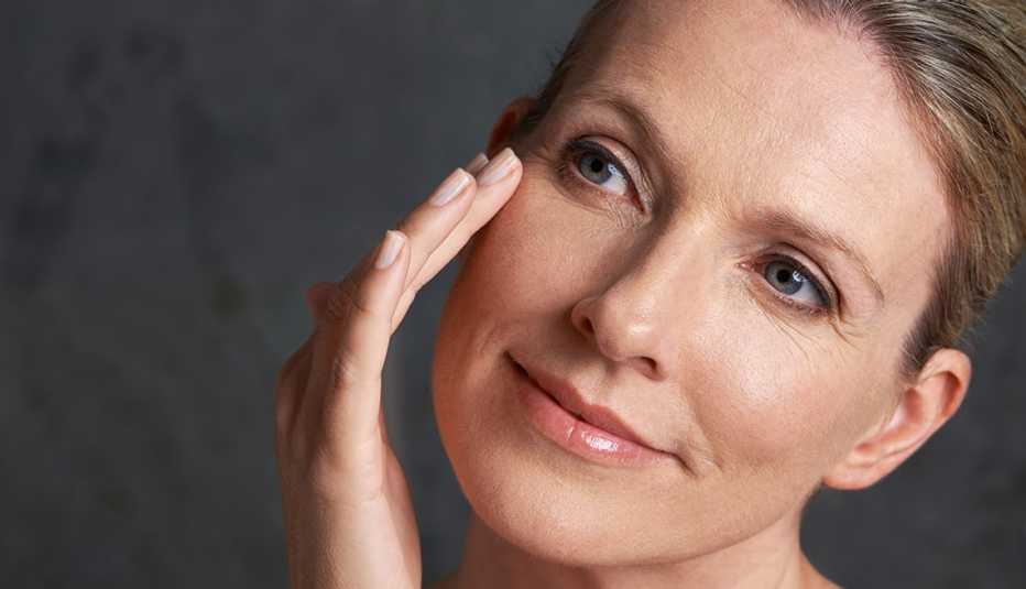 mature woman applying cream on her face