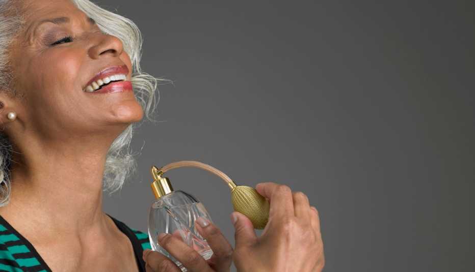 Black woman spraying perfume on her neck