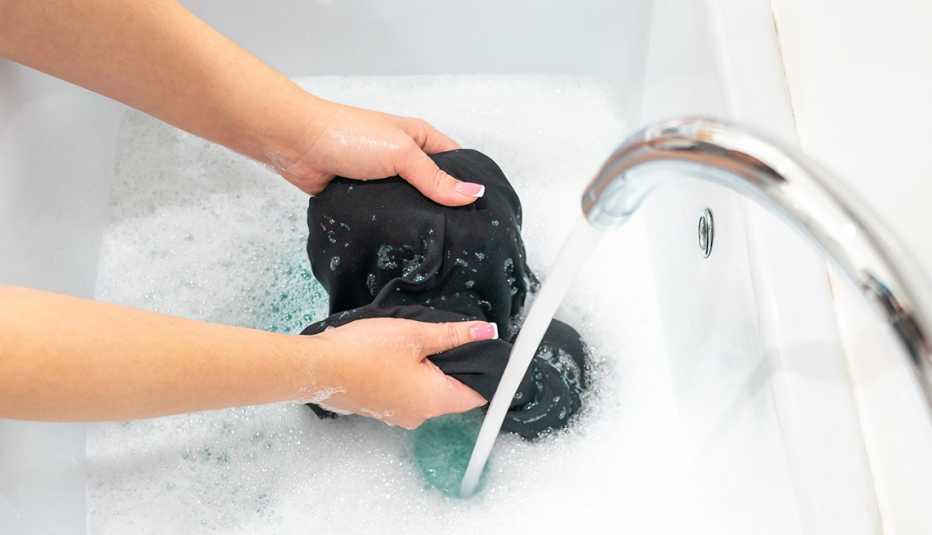 A woman hand washing clothes in a basin