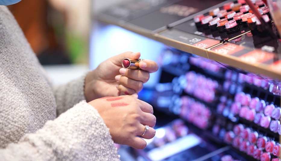 A woman testing a lipstick shade by applying it to the top of her hand