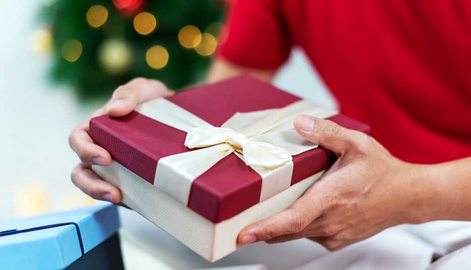 a man holding a gift box with a bow a man holding a gift box with a bow