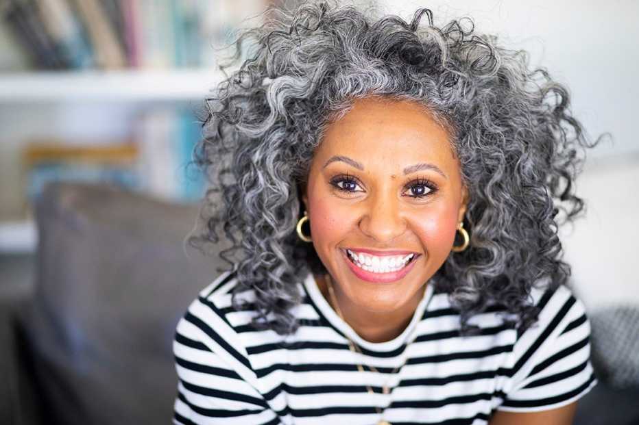 A woman wearing a black and white striped shirt smiling
