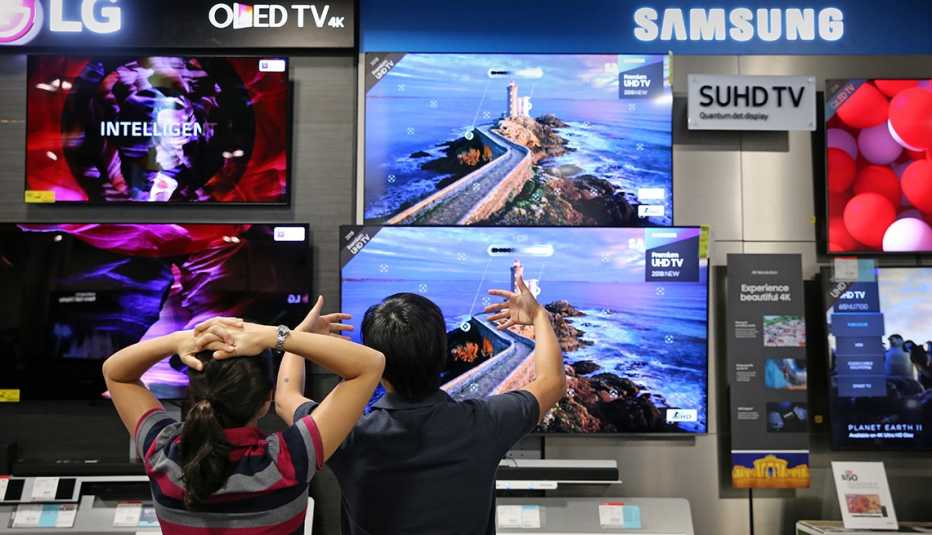A couple discuss televisions while shopping at Best Buy 