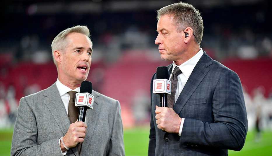 espn's joe buck and troy aikman holding their microphones during their broadcast before the game between the dallas cowboys and tampa bay buccaneers