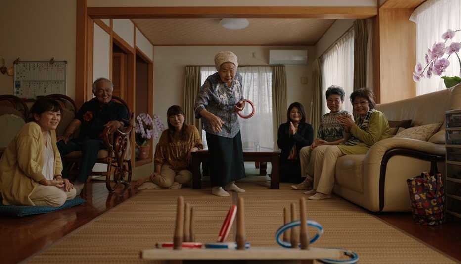 umeto yamashiro playing a game with other people watching in the netflix docuseries live to 100 secrets of the blue zones