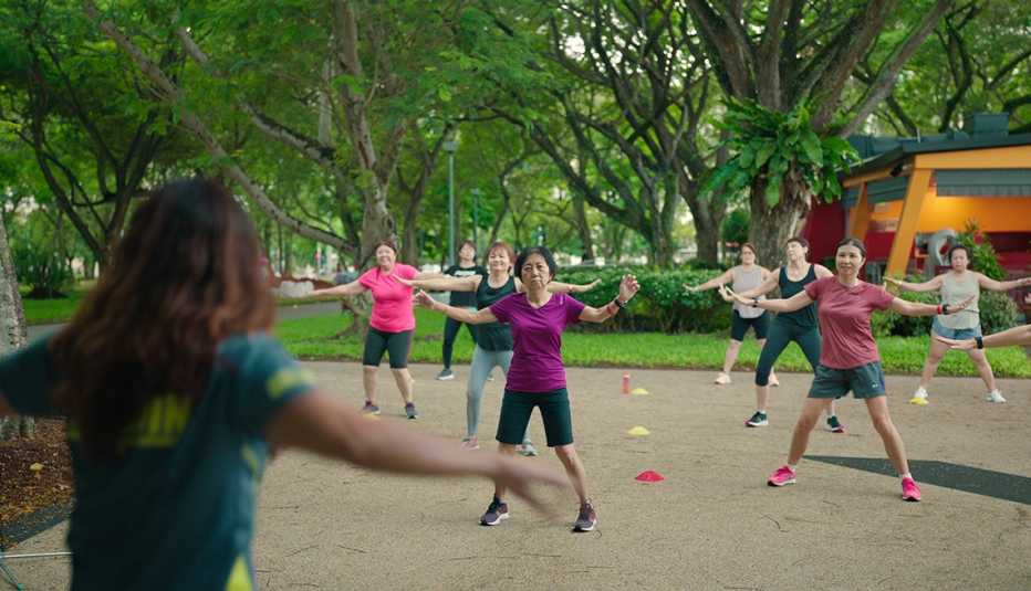 a group of people exercising in a park together in the netflix docuseries live to 100 secrets of the blue zones