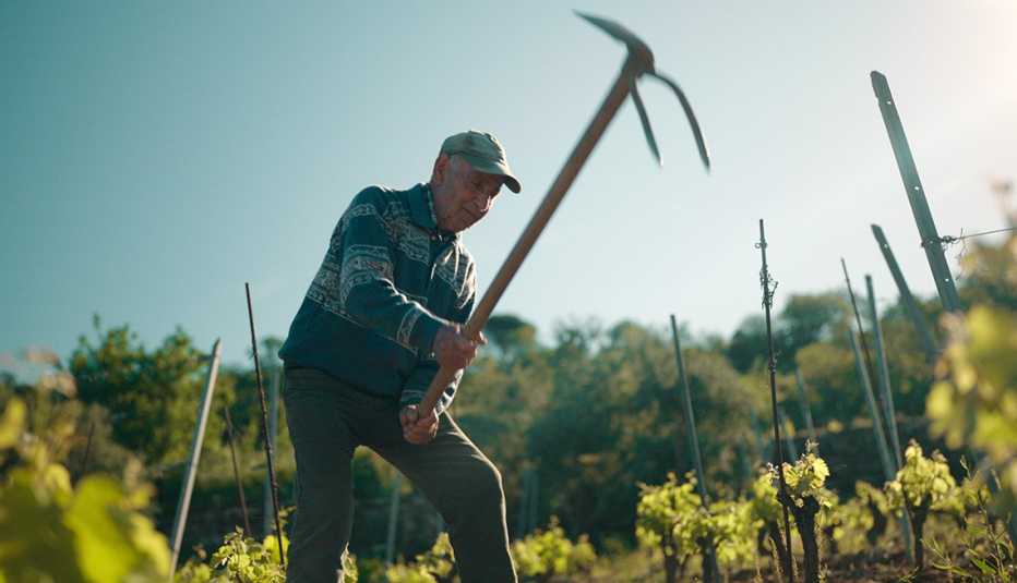 a man working in a field in the netflix docuseries live to 100 secrets of the blue zones
