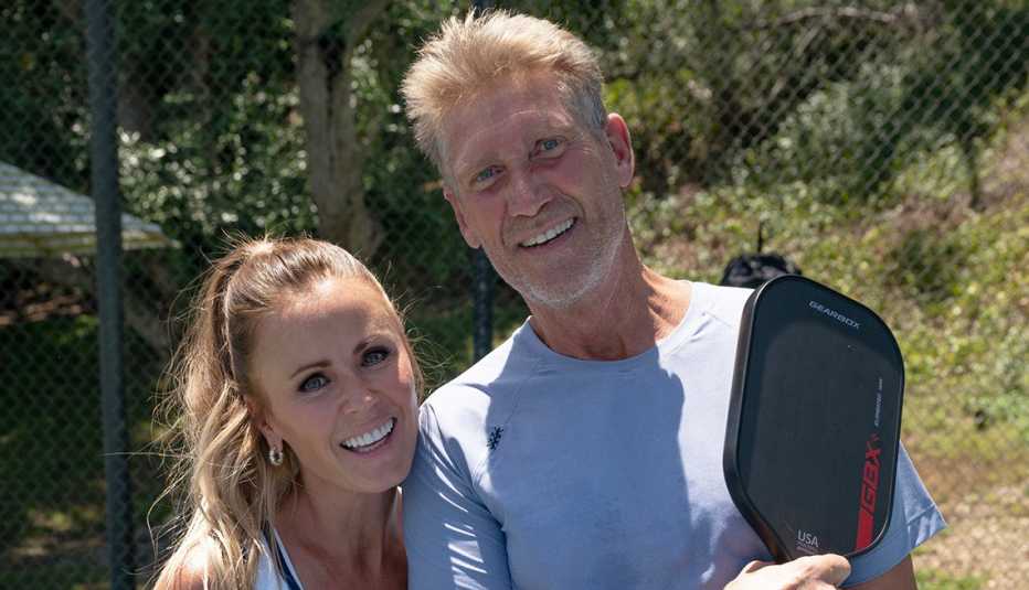 trista sutter and gerry turner holding pickleball rackets on the set of the golden bachelor