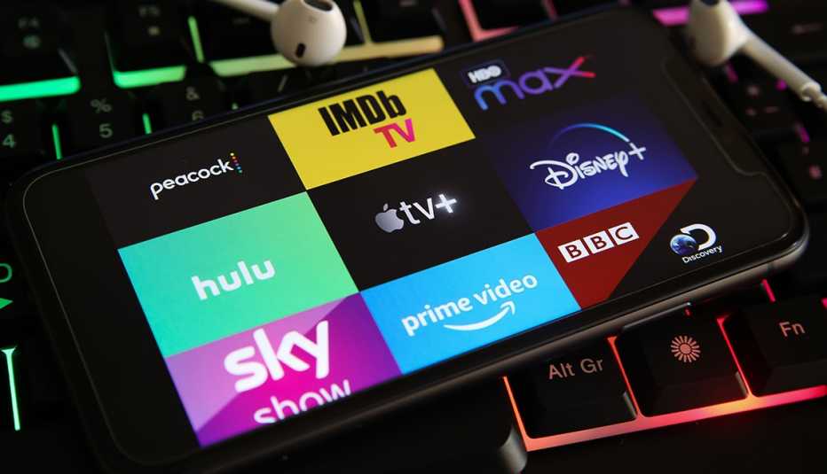 A smartphone showing logos of different streaming services on the screen
