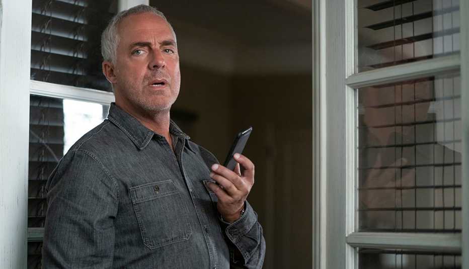 Titus Welliver holds a cell phone in a scene from Bosch Legacy