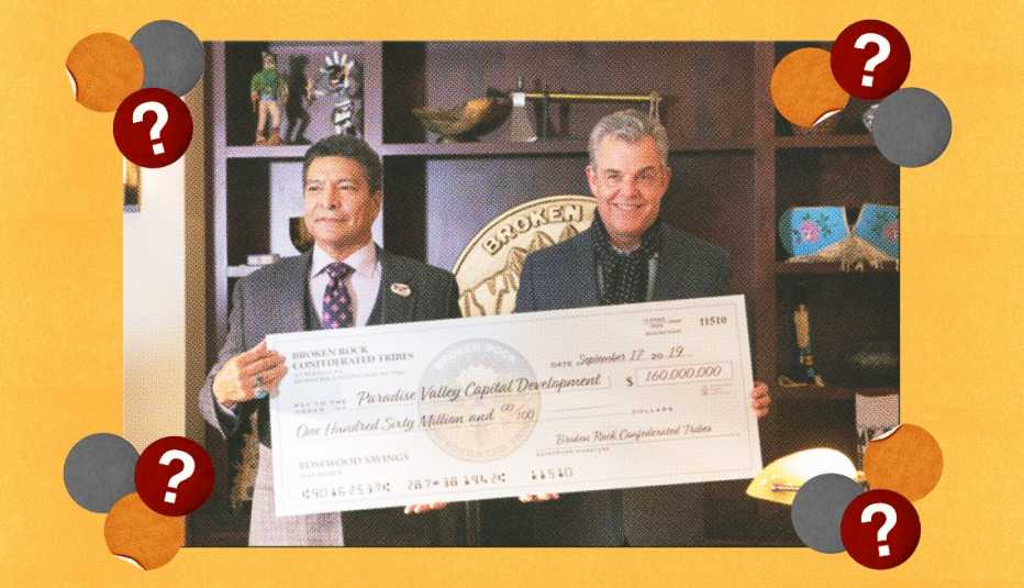 two men holding a large check in a scene from yellowstone
