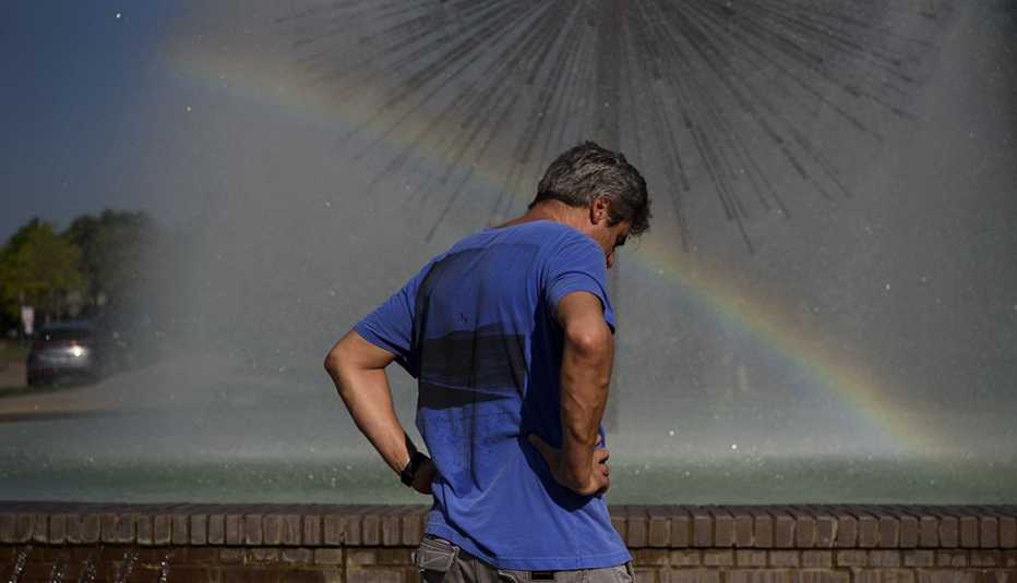 A man stands next to a fountain