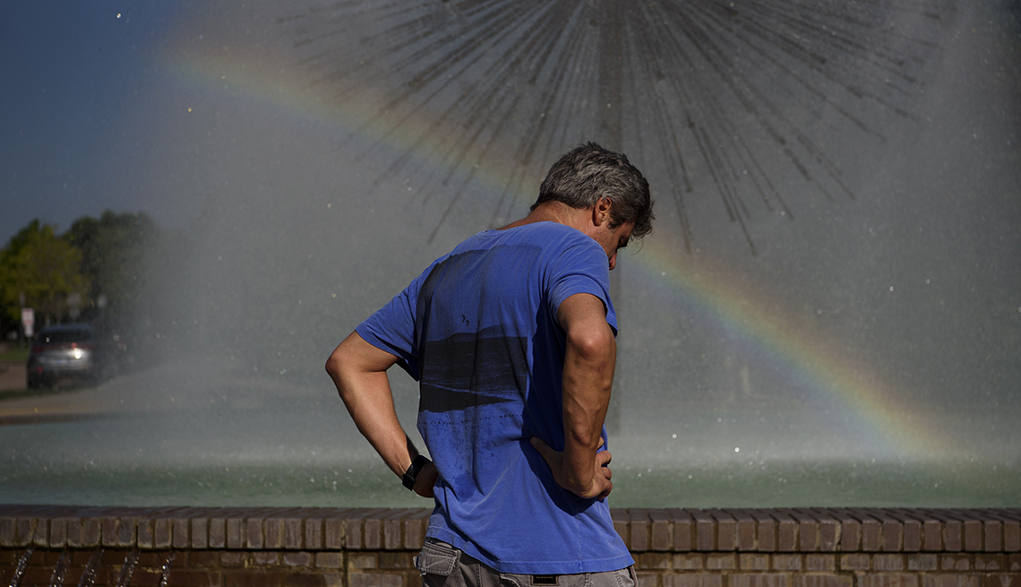 A man stands next to a fountain