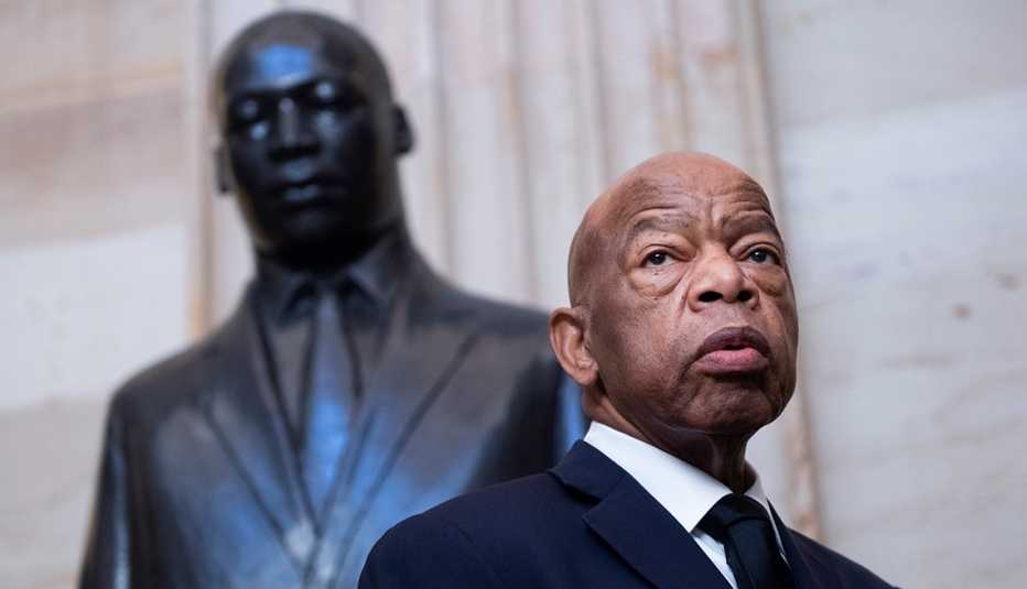 John Lewis stands in front of a statue of Martin Luther King Junior