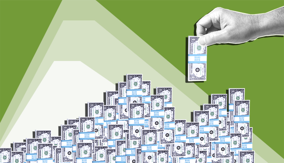 hand placing miniature bundle of dollar bills onto pile of many other bundles