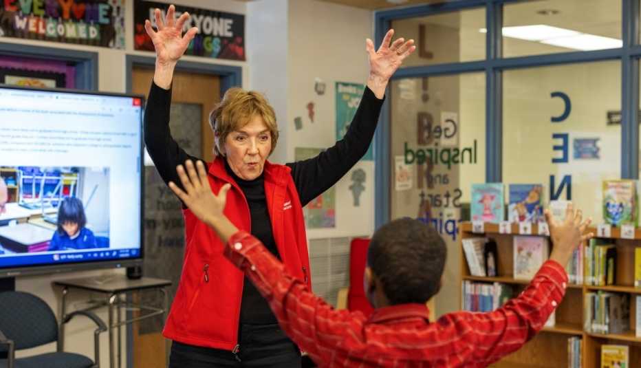 Meg Quinn, AARP Foundation Experience Corps volunteer playing a mirror game with a child