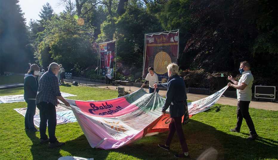 Gert McMullin leads the unfolding of a quilt panel at the National AIDS Memorial where 40 Quilt blocks were displayed, symbolizing four decades of the AIDS pandemic. 
