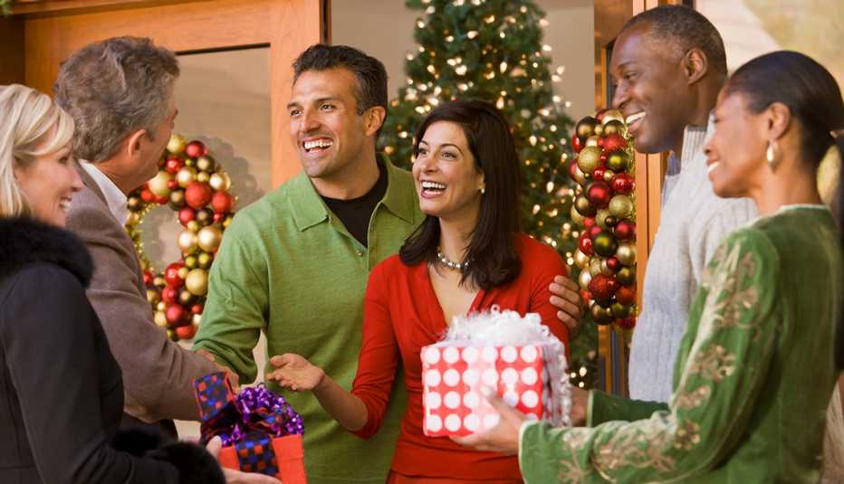 A group of people gathered for a holiday party, dressed casually in solid colors. 
