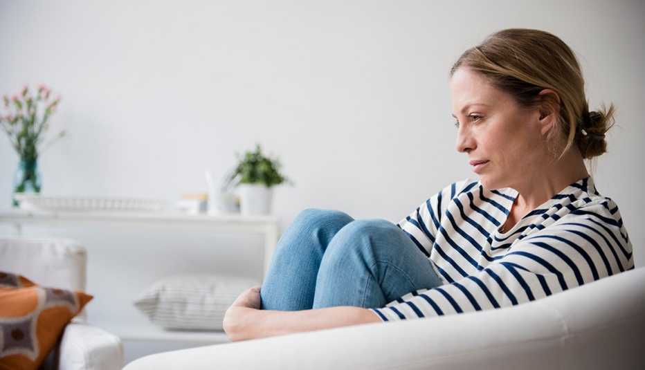 woman sitting by herself sitting on a couch woman sitting by herself sitting on a couch