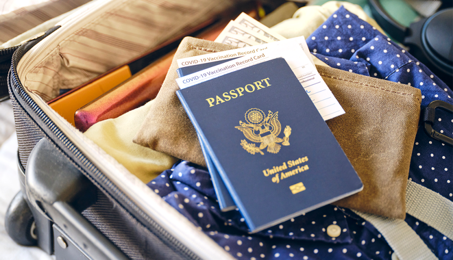 a suitcase ready for travel with passports and covid vaccination cards