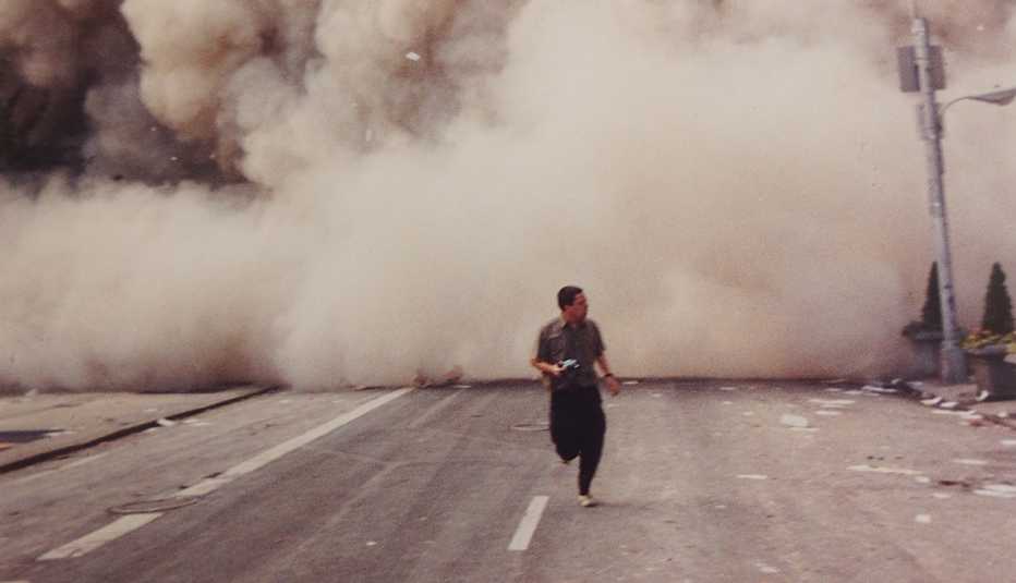 editor george mannes runs from the twin towers in new york city on september eleventh surrounded by a huge dust cloud