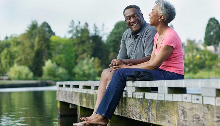 A man and woman sitting on a pier