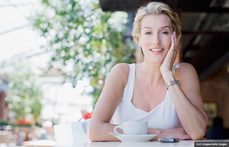 Woman drinking coffee at a cafe. Your online dating questions answered. (OJO Images/Getty Images)