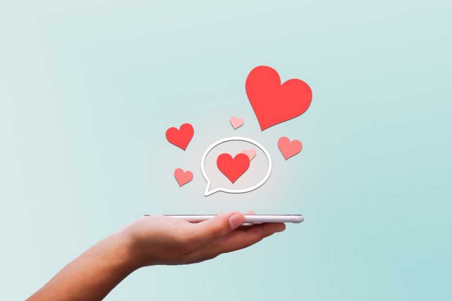  Person holds phone while hearts and speech bubbles fly out