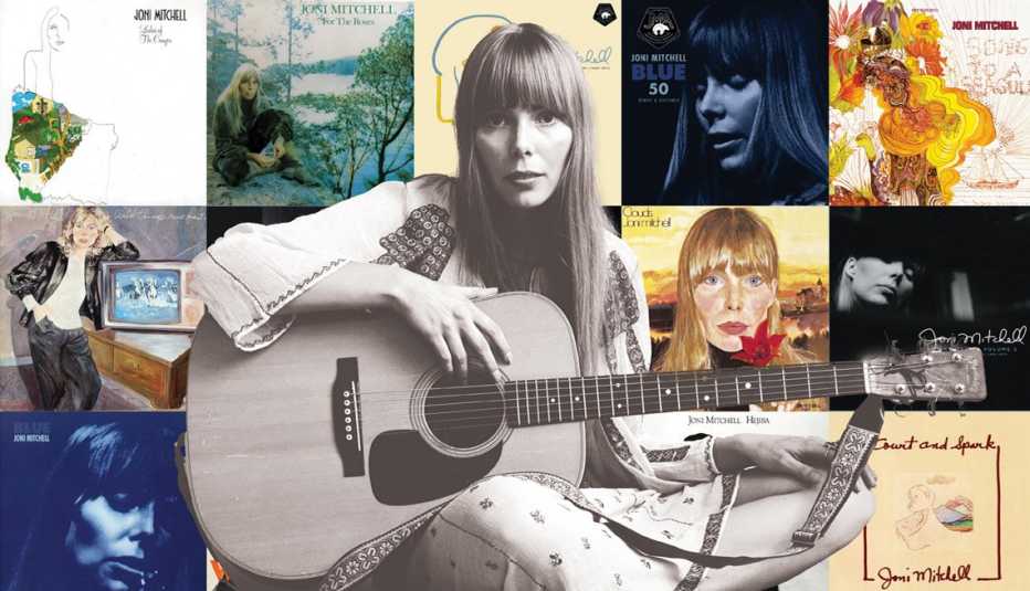 Joni Mitchell holding guitar against background of Joni Mitchell album covers