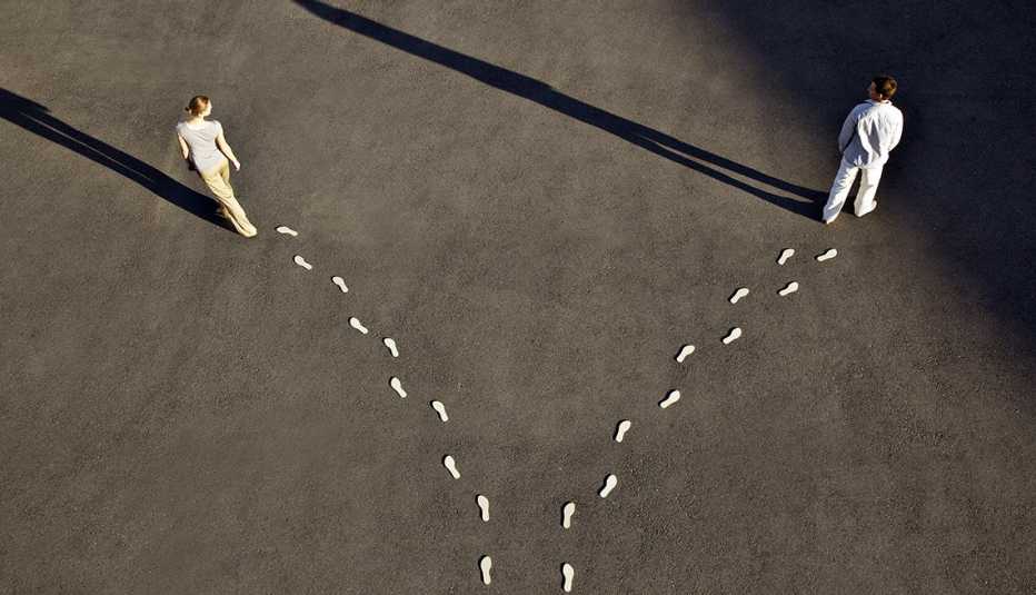 high angle of a couple headed in different directions with a diverging line of footprints trailing behind