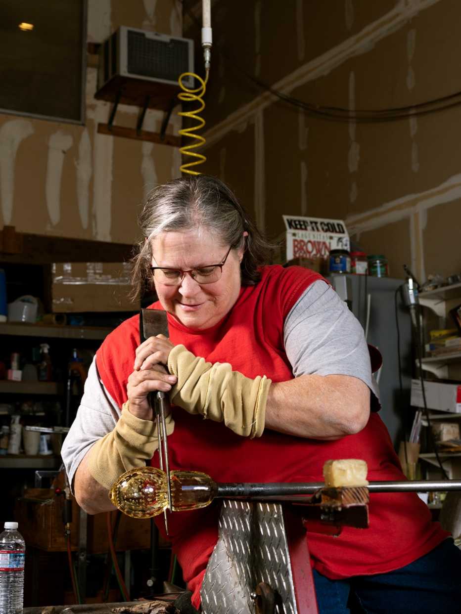 artist linnea wong works on shaping a blown glass project in an art studio