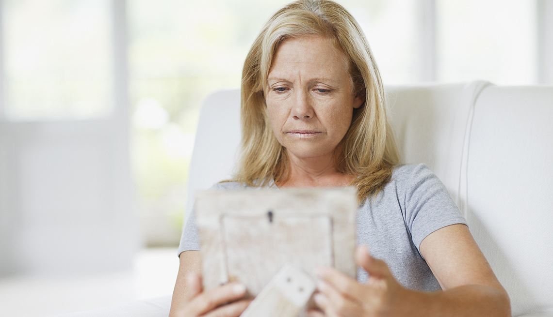 Sad woman, looking at a photo, grieving