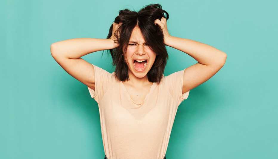 woman holding her head and yelling